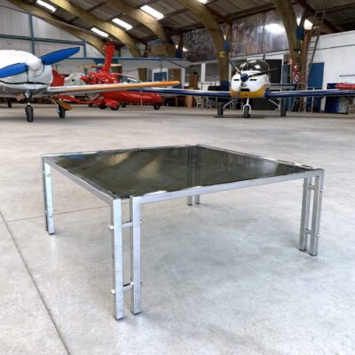 Table basse carré en verre et chrome vue de côté